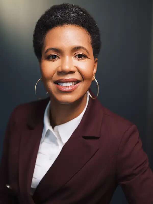 Photo of Professor Angela Simms wearing a white shirt under a brown blazer